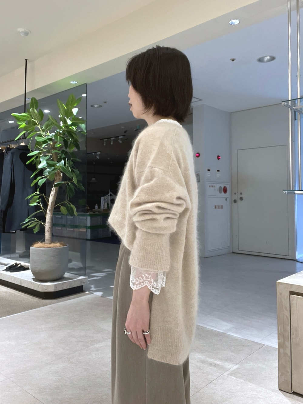 ベージュ系のスラックス、ブラウン系のトートバッグ、ブラウン系のブーツを着用したレディースの秋コーディネートの5枚目の写真