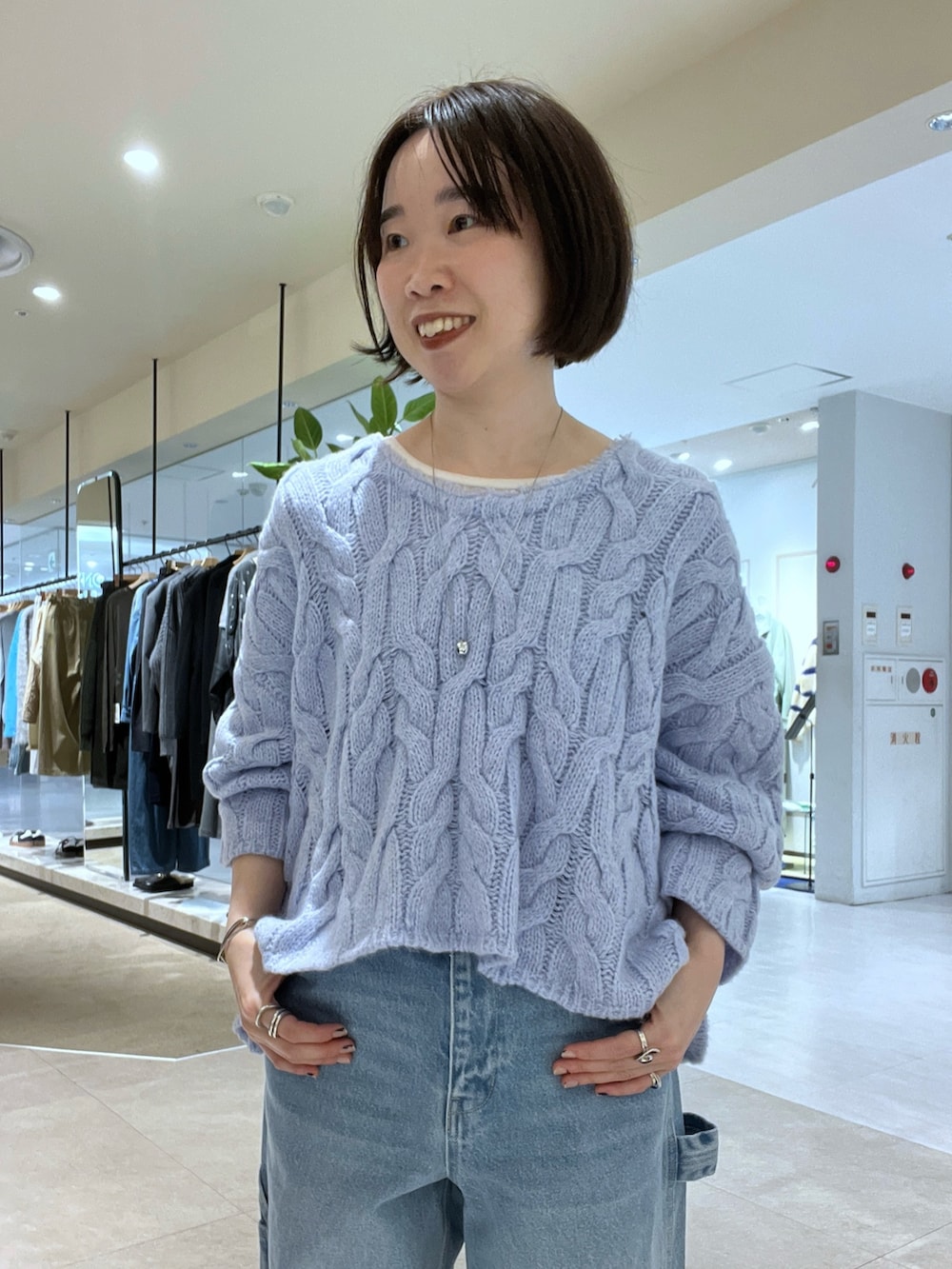 ブルー系のデニムパンツ、ブラウン系のボストンバッグ、ブラウン系のブーツを着用したレディースの秋コーディネートの9枚目の写真