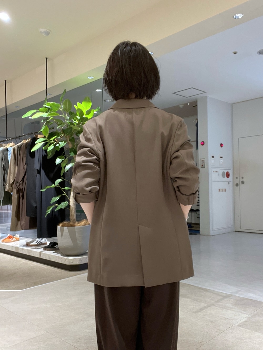 ブラウン系のスラックス、ブラック系のパンプス、ブラウン系のTシャツ/カットソーを着用したレディースの秋コーディネートの7枚目の写真