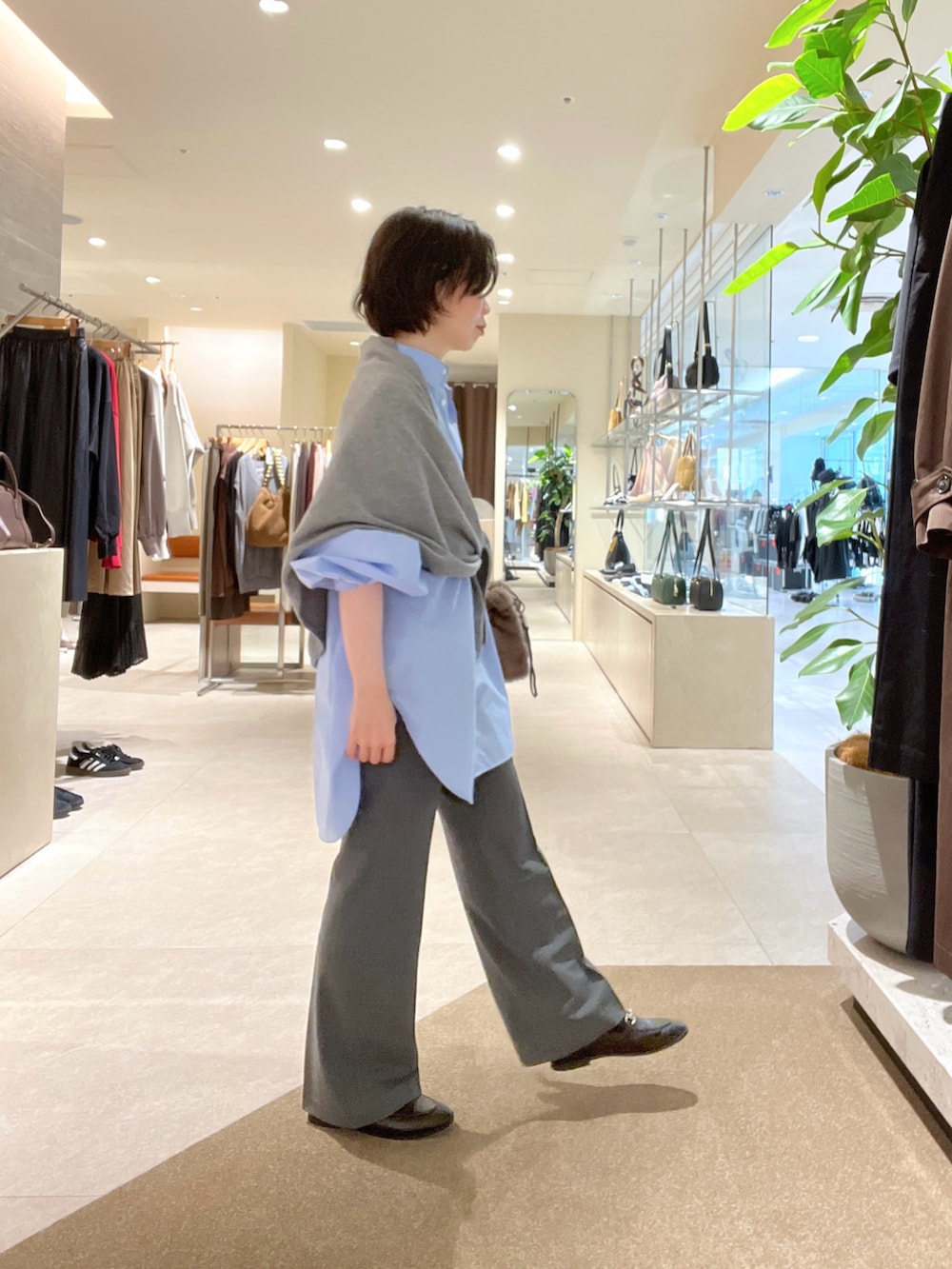 ブルー系のシャツ/ブラウス、グレー系のその他パンツ、ブラウン系のハンドバッグを着用したレディースの秋コーディネートの2枚目の写真