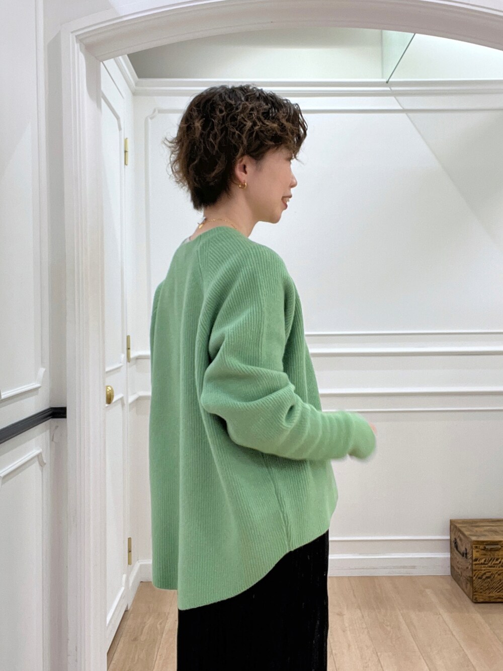 ブラック系のスカート、グリーン系のニット/セーター、ブラック系のショルダーバッグを着用したレディースの冬コーディネートの5枚目の写真