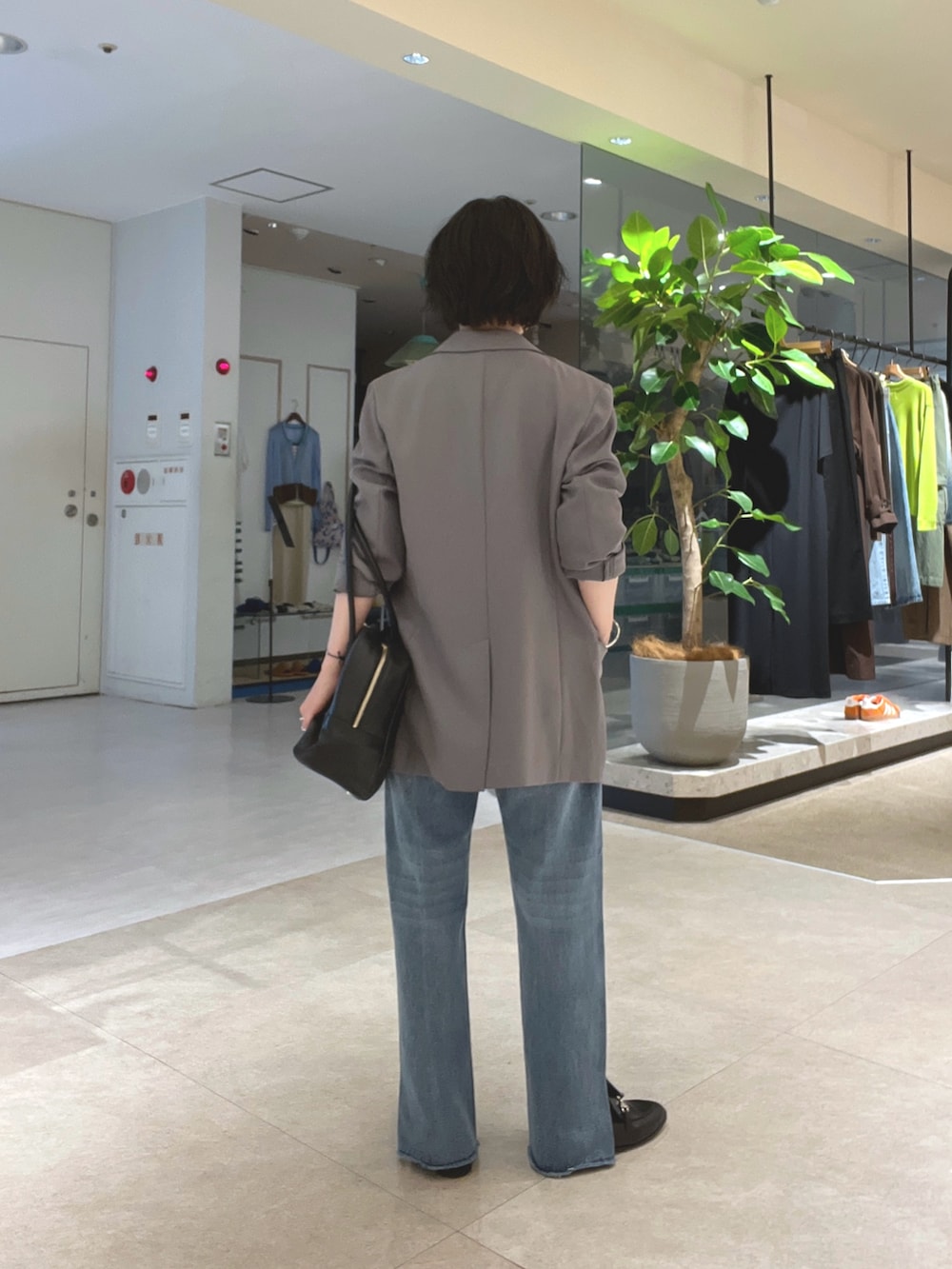 ホワイト系のTシャツ/カットソー、ブルー系のデニムパンツ、ブラック系のローファーを着用したレディースの秋コーディネートの3枚目の写真