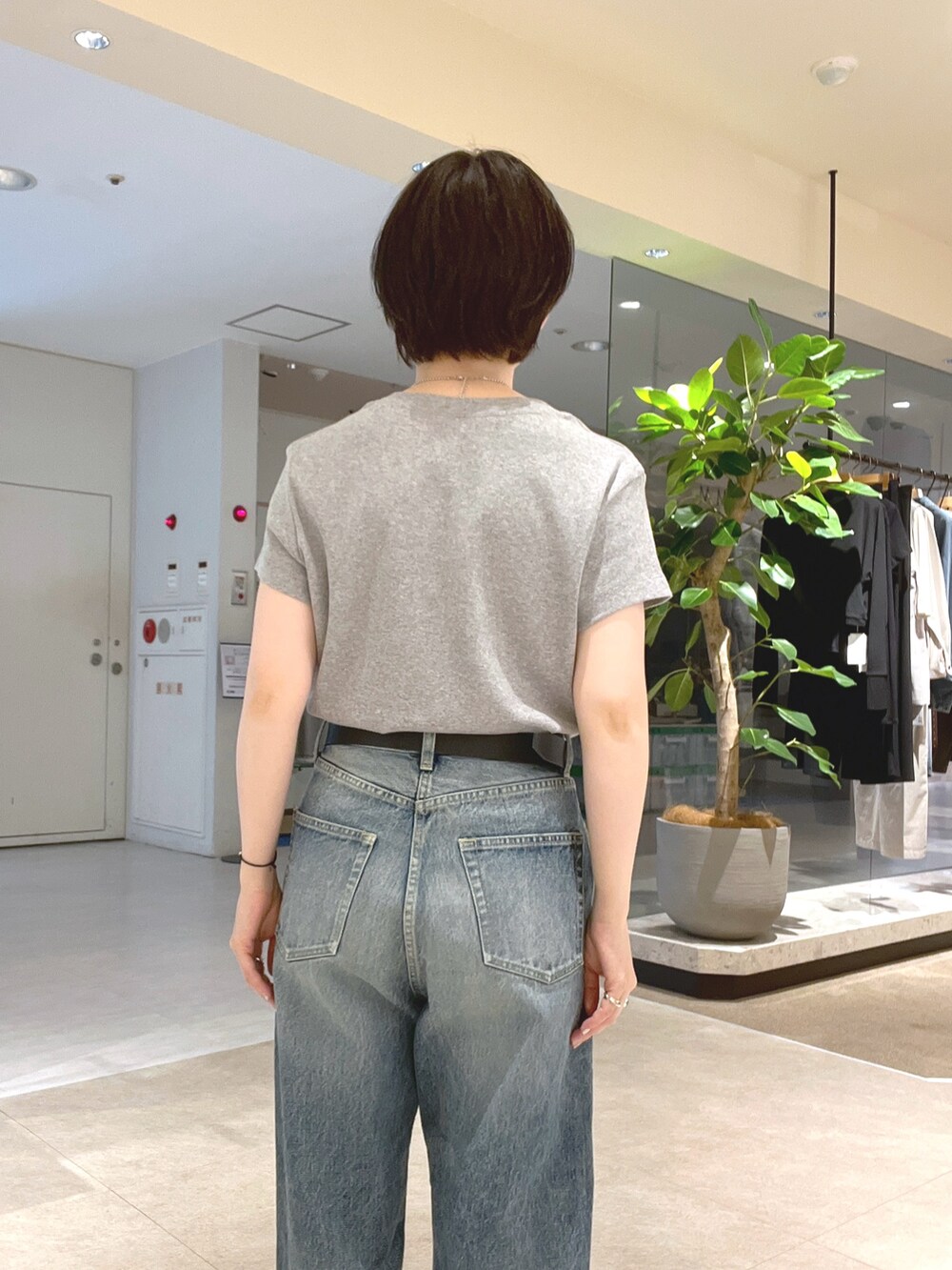 ブルー系のデニムパンツ、ブラック系のサンダル、グレー系のTシャツ/カットソーを着用したレディースの夏コーディネートの6枚目の写真