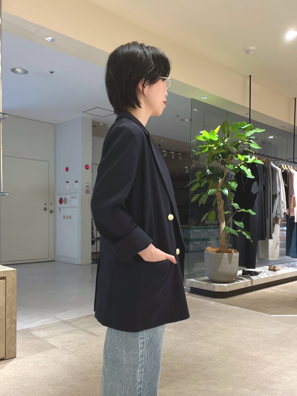 ブルー系のデニムパンツ、ブラック系のパンプス、ブラック系のボストンバッグを着用したレディースの夏コーディネートの5枚目の写真