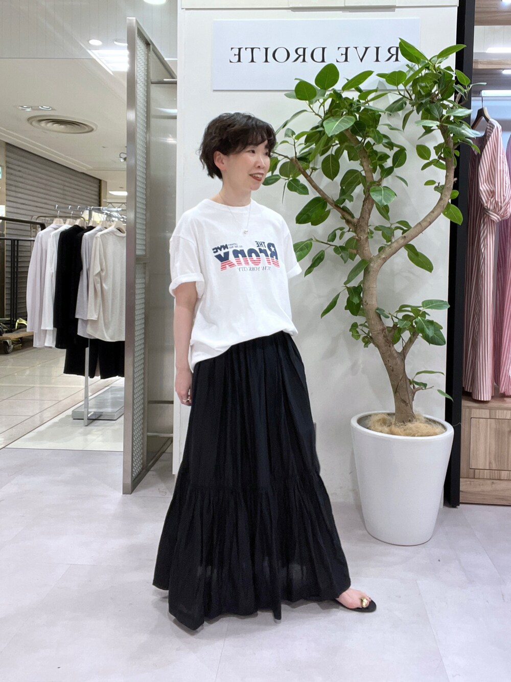 ブラック系のスカート、ホワイト系のシャツ/ブラウス、ホワイト系のTシャツ/カットソーを着用したレディースの春コーディネートの3枚目の写真