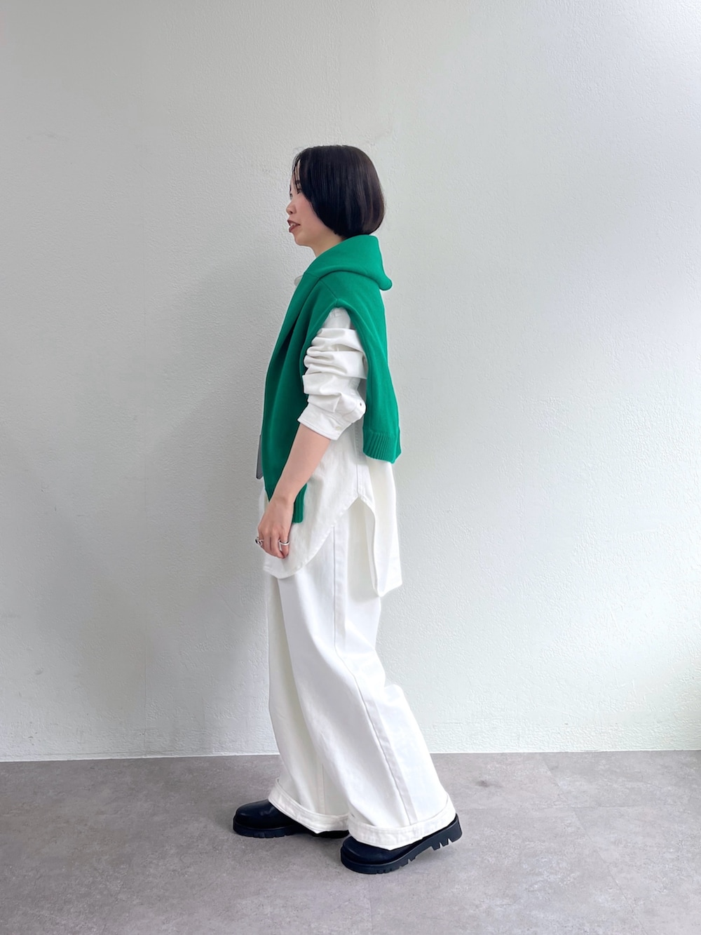 ホワイト系のシャツ/ブラウス、グリーン系のニット/セーター、ホワイト系のデニムパンツを着用したレディースの冬コーディネートの2枚目の写真