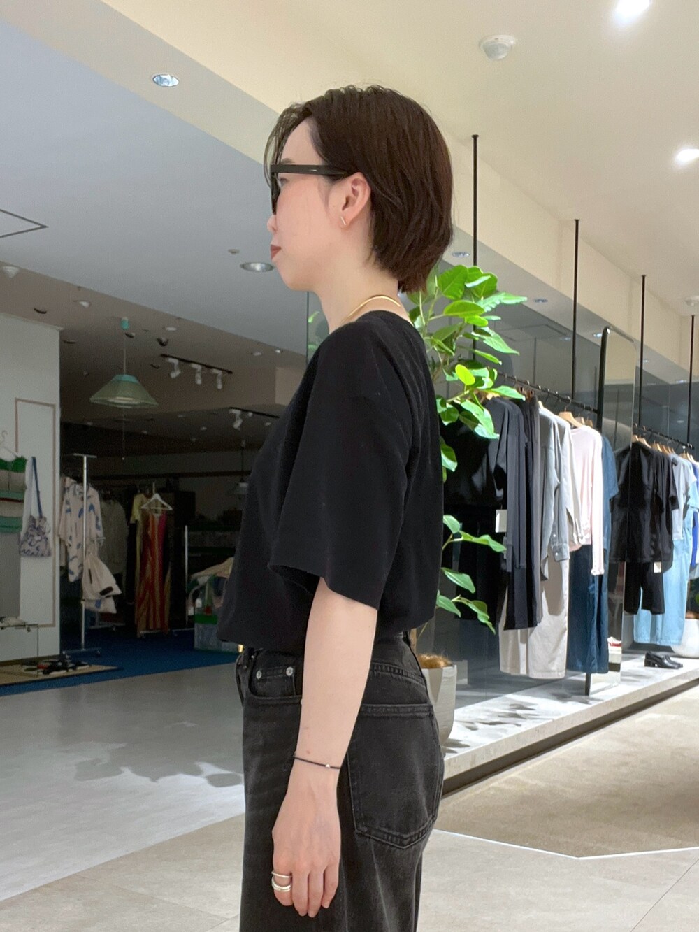 ブラック系のデニムパンツ、ブラック系のTシャツ/カットソー、ブラック系のサングラスを着用したレディースの夏コーディネートの3枚目の写真