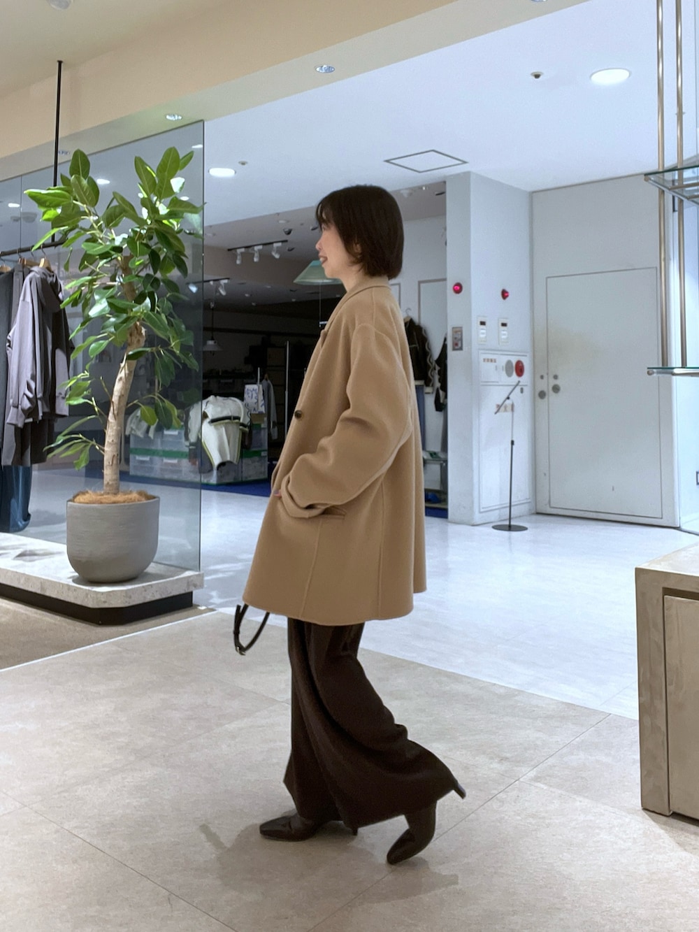 イエロー系のその他アウター、ホワイト系のニット/セーター、ブラウン系のスラックスを着用したレディースの秋コーディネートの2枚目の写真