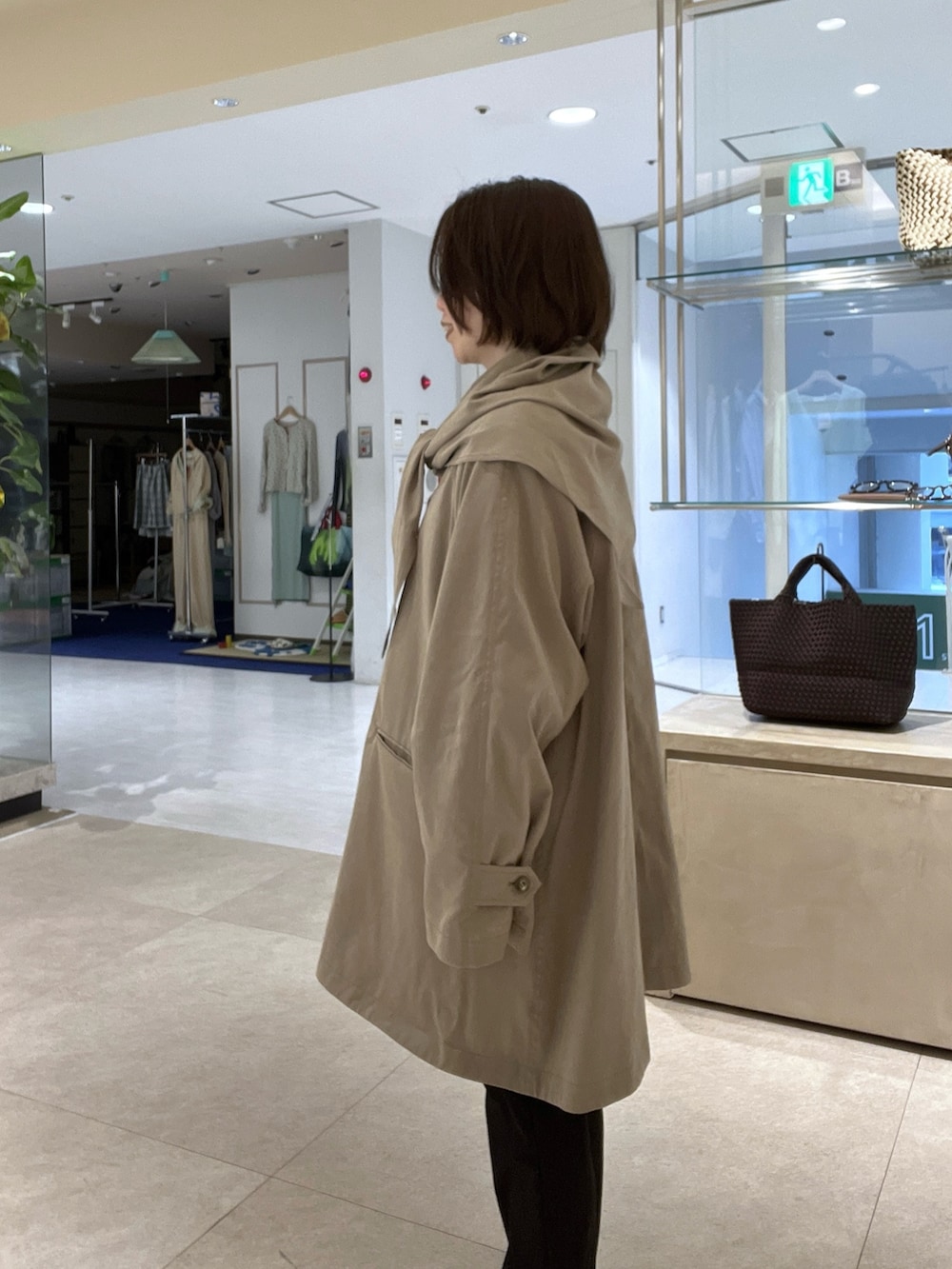 ベージュ系のその他アウター、ブラック系のその他パンツ、ブルー系のシャツ/ブラウスを着用したレディースの冬コーディネートの5枚目の写真