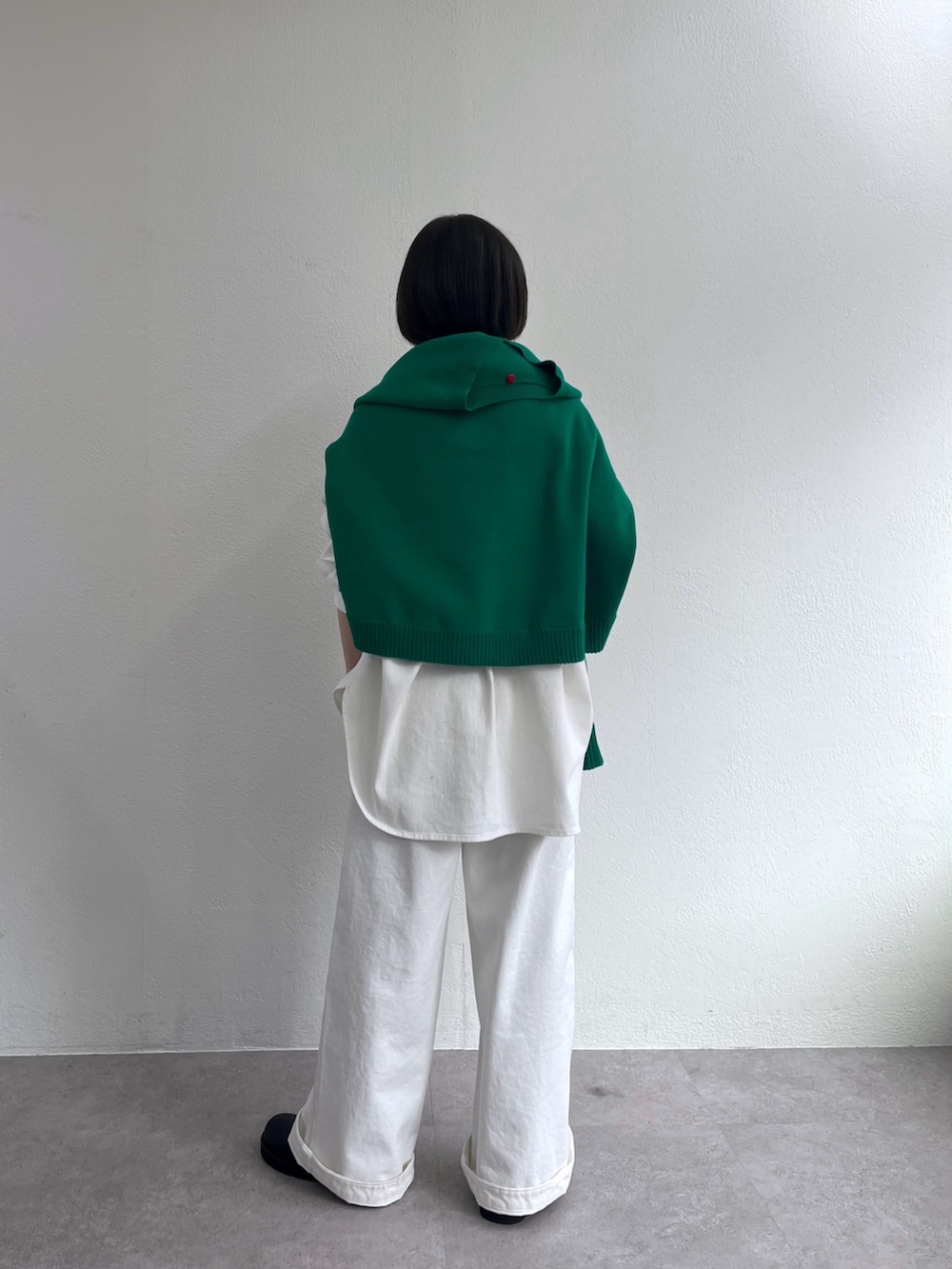 ホワイト系のシャツ/ブラウス、グリーン系のニット/セーター、ホワイト系のデニムパンツを着用したレディースの冬コーディネートの3枚目の写真