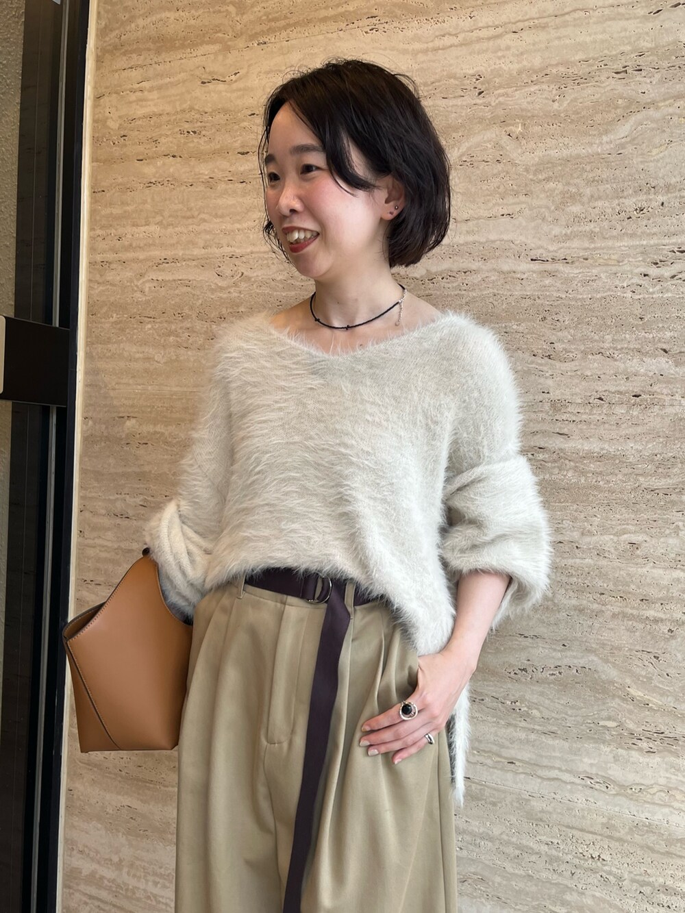 ホワイト系のニット/セーター、ベージュ系のチノパンツ、イエロー系のハンドバッグを着用したレディースの秋コーディネートの5枚目の写真