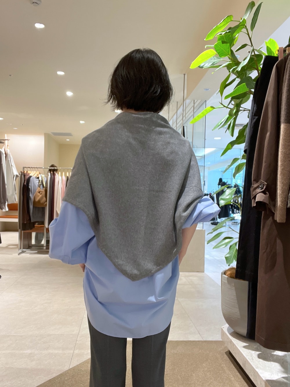 ブルー系のシャツ/ブラウス、グレー系のその他パンツ、ブラウン系のハンドバッグを着用したレディースの秋コーディネートの5枚目の写真