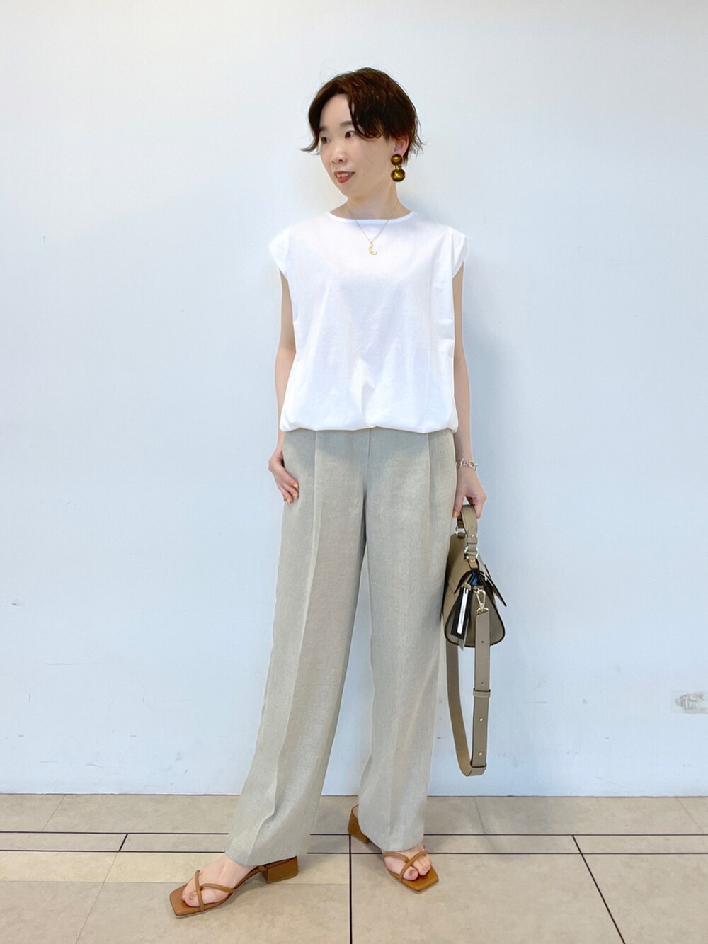 ホワイト系のTシャツ/カットソー、グリーン系のワンピース、ベージュ系のその他パンツを着用したレディースの春コーディネートの5枚目の写真