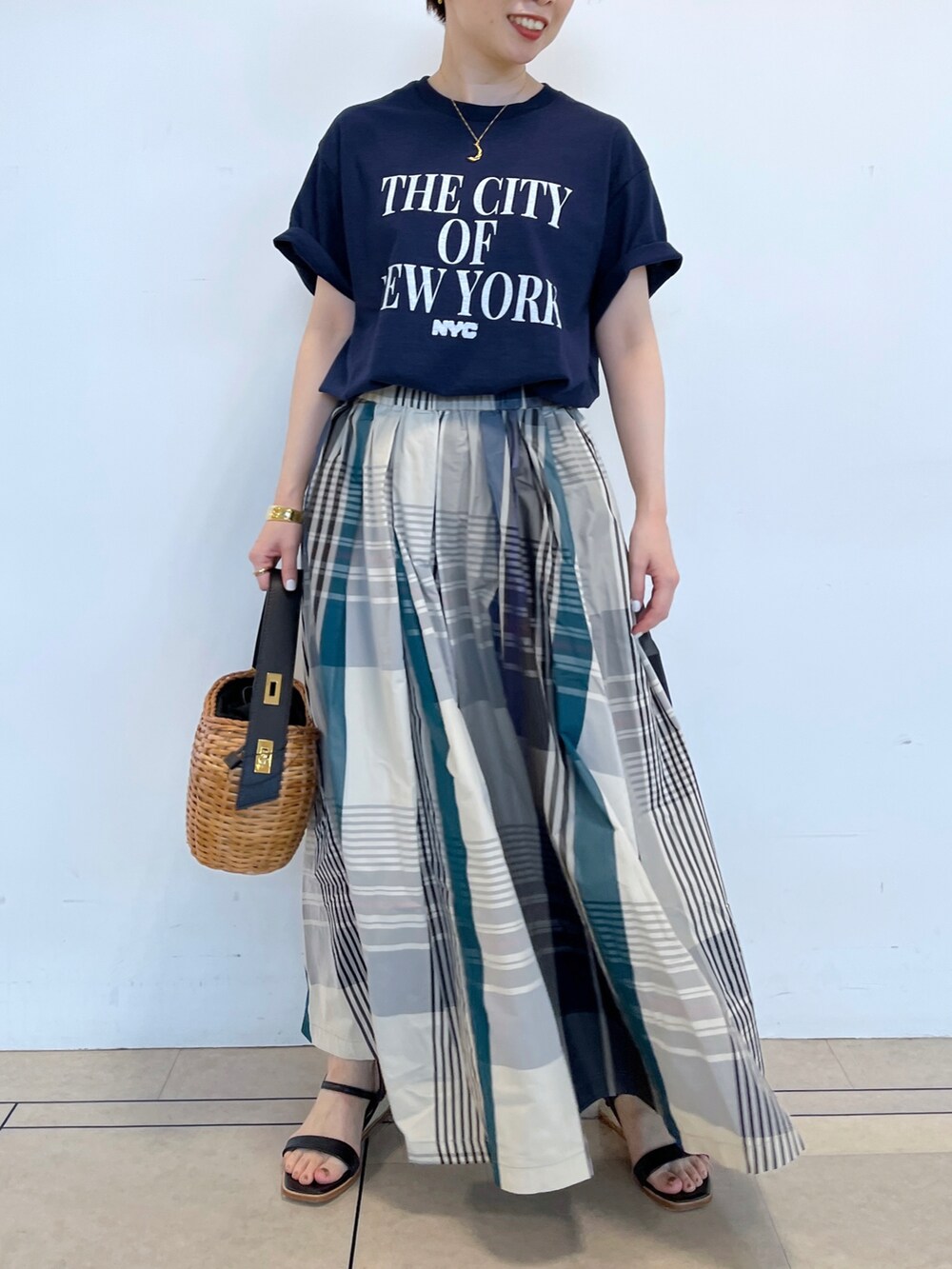 ブルー系のスカート、ブルー系のTシャツ/カットソー、ブラック系のサンダルを着用したレディースの春コーディネートの3枚目の写真