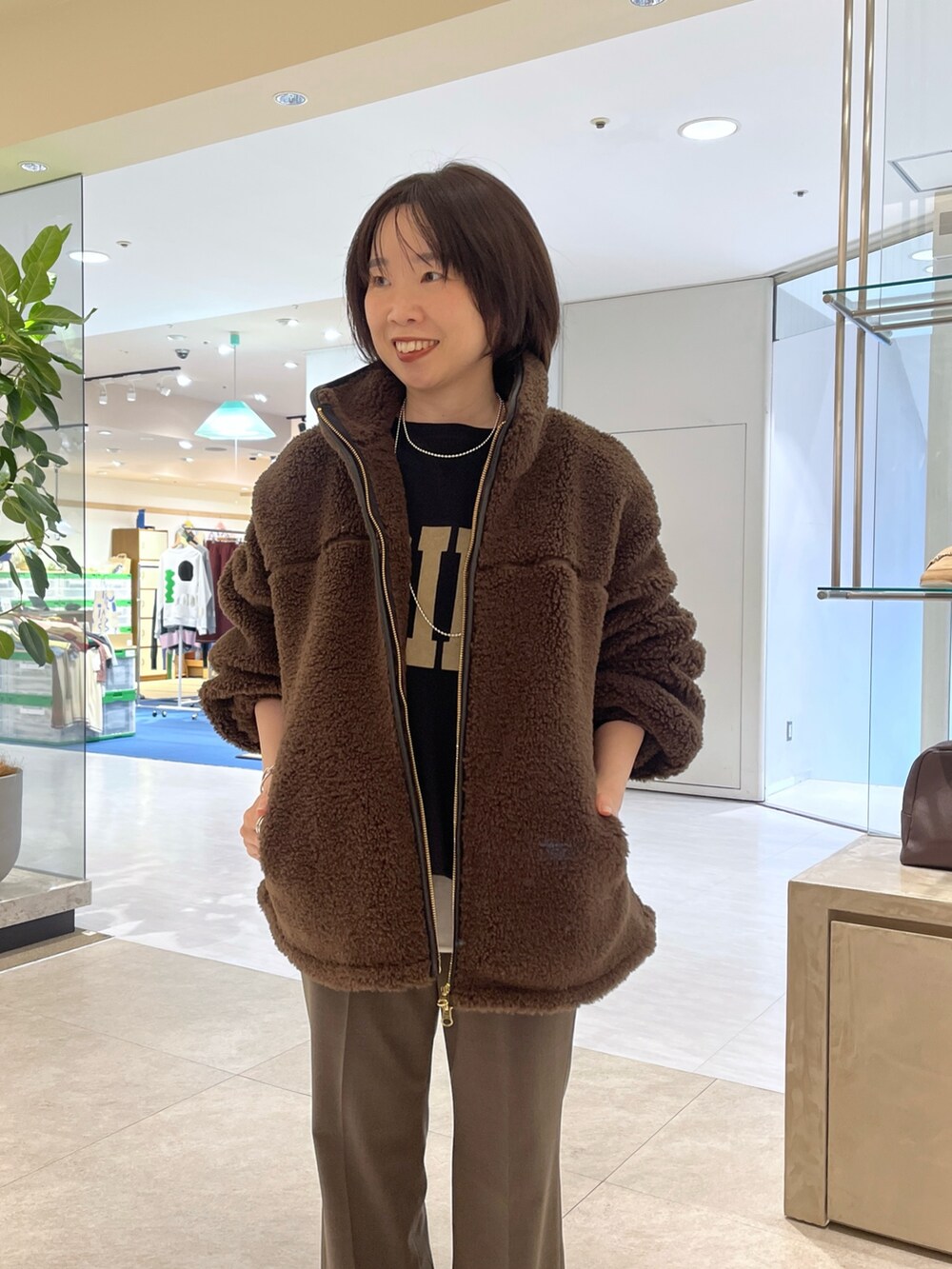 ブラウン系のその他パンツ、ブラウン系のボストンバッグ、ブラウン系のブーツを着用したレディースの秋コーディネートの3枚目の写真