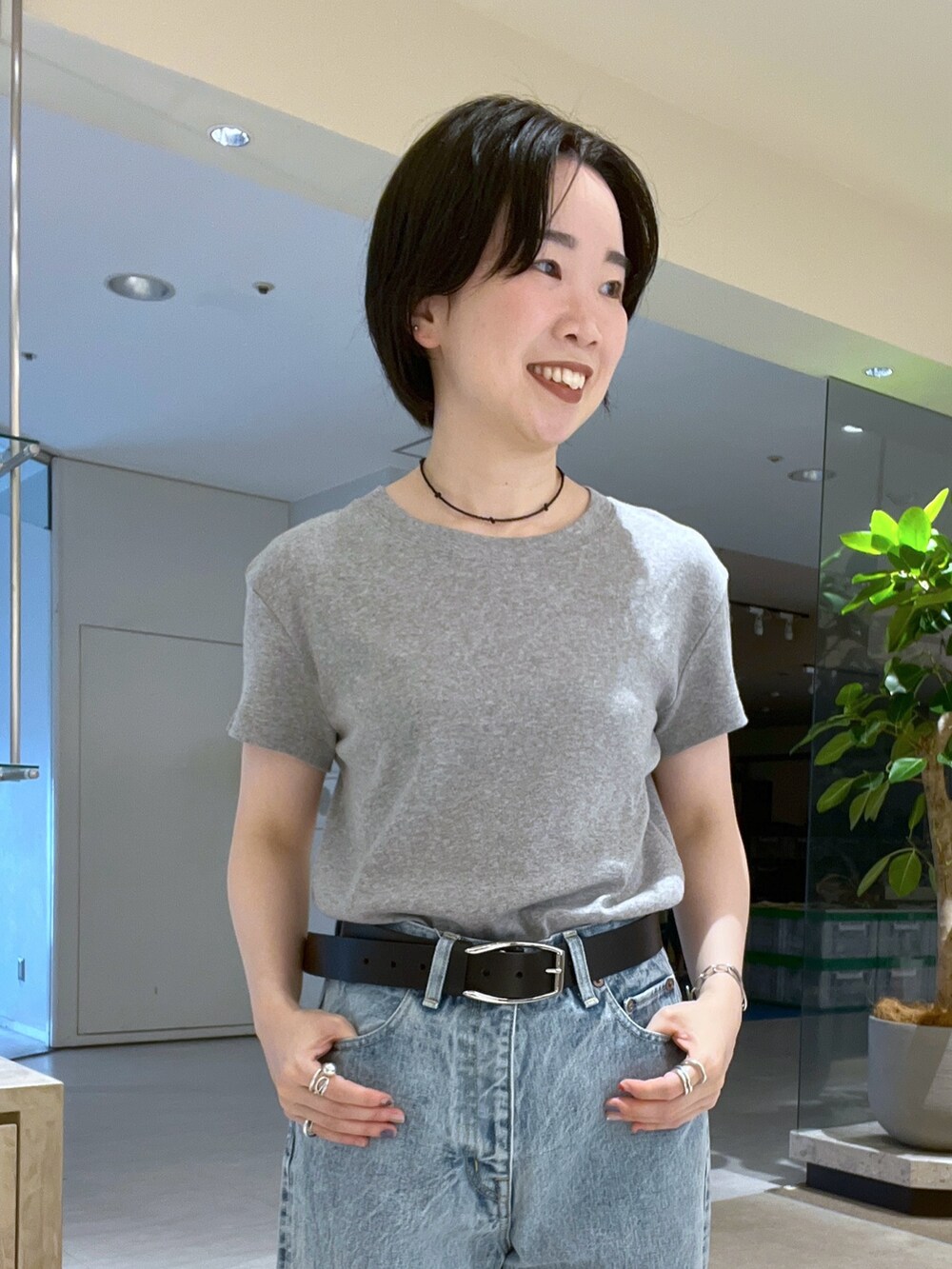 グレー系のTシャツ/カットソー、ブルー系のデニムパンツ、ブラック系のパンプスを着用したレディースの夏コーディネートの5枚目の写真