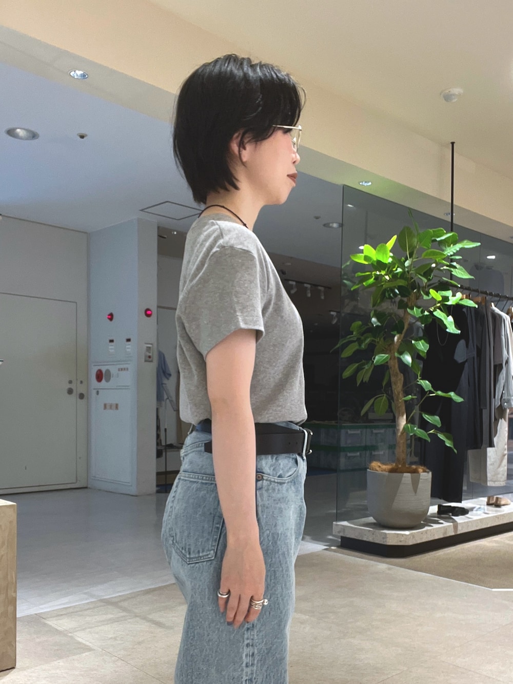 ブルー系のデニムパンツ、ブラック系のパンプス、ブラック系のボストンバッグを着用したレディースの夏コーディネートの8枚目の写真