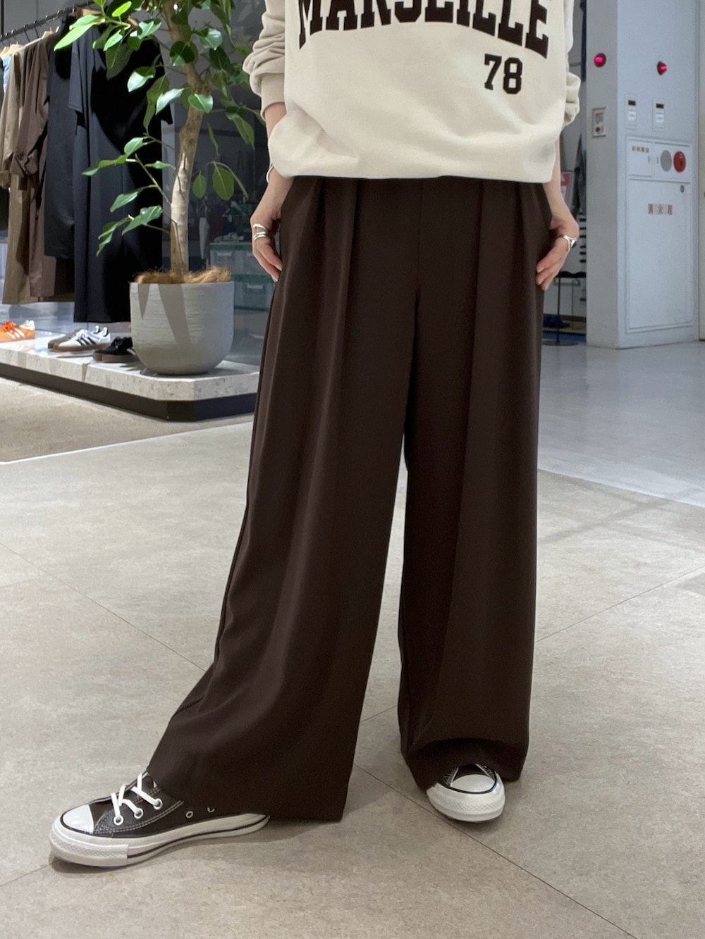 ブラウン系のスラックス、ホワイト系のスウェット、ブラック系のバックパック/リュックを着用したレディースの秋コーディネートの5枚目の写真