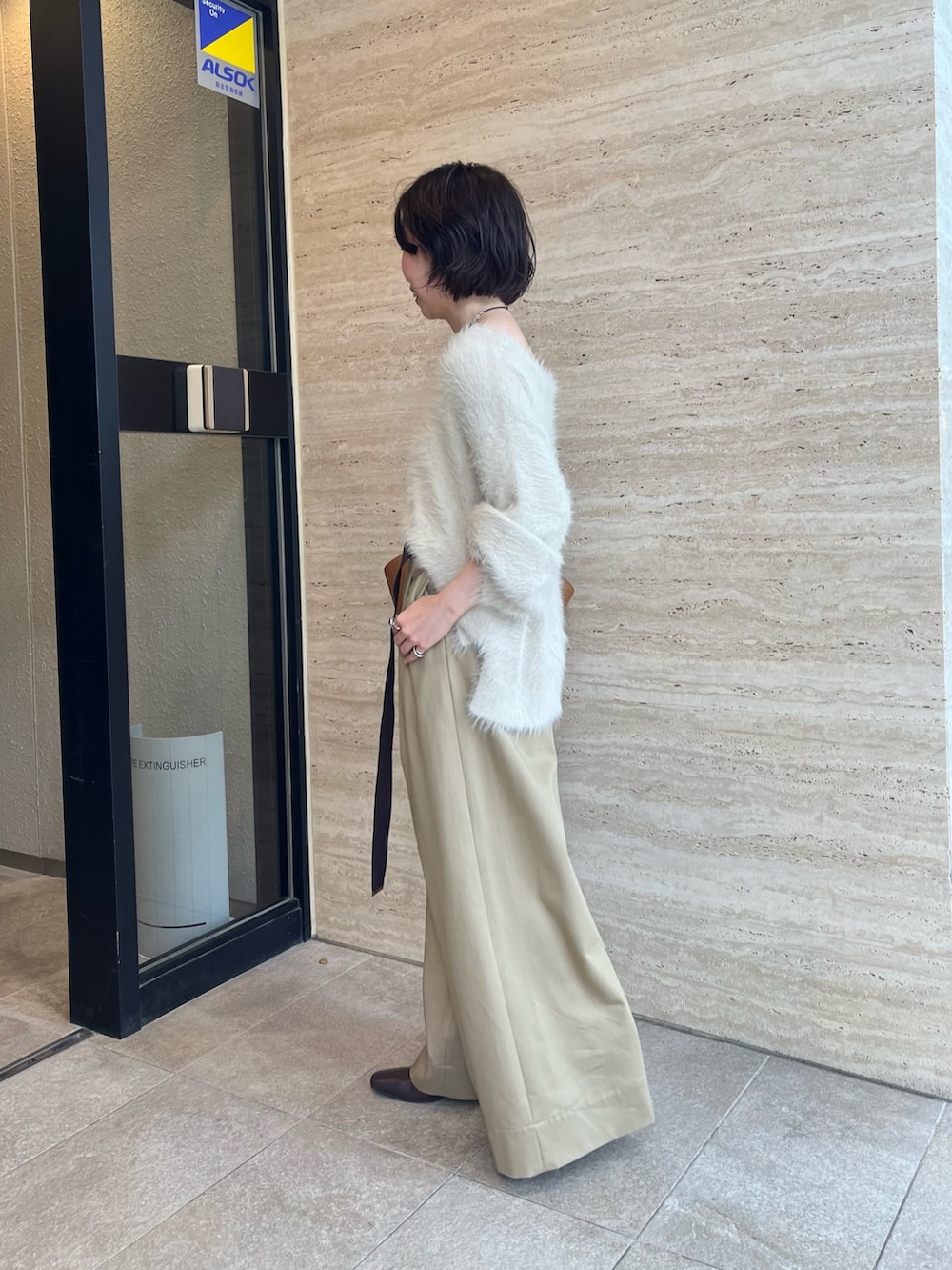 ホワイト系のニット/セーター、ベージュ系のチノパンツ、イエロー系のハンドバッグを着用したレディースの秋コーディネートの2枚目の写真