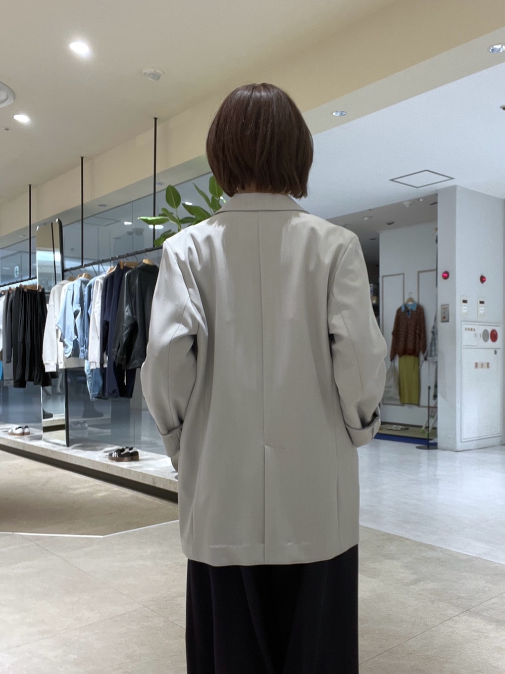 グレー系のテーラードジャケット、ブルー系のスラックス、ブラック系のボストンバッグを着用したレディースの冬コーディネートの6枚目の写真