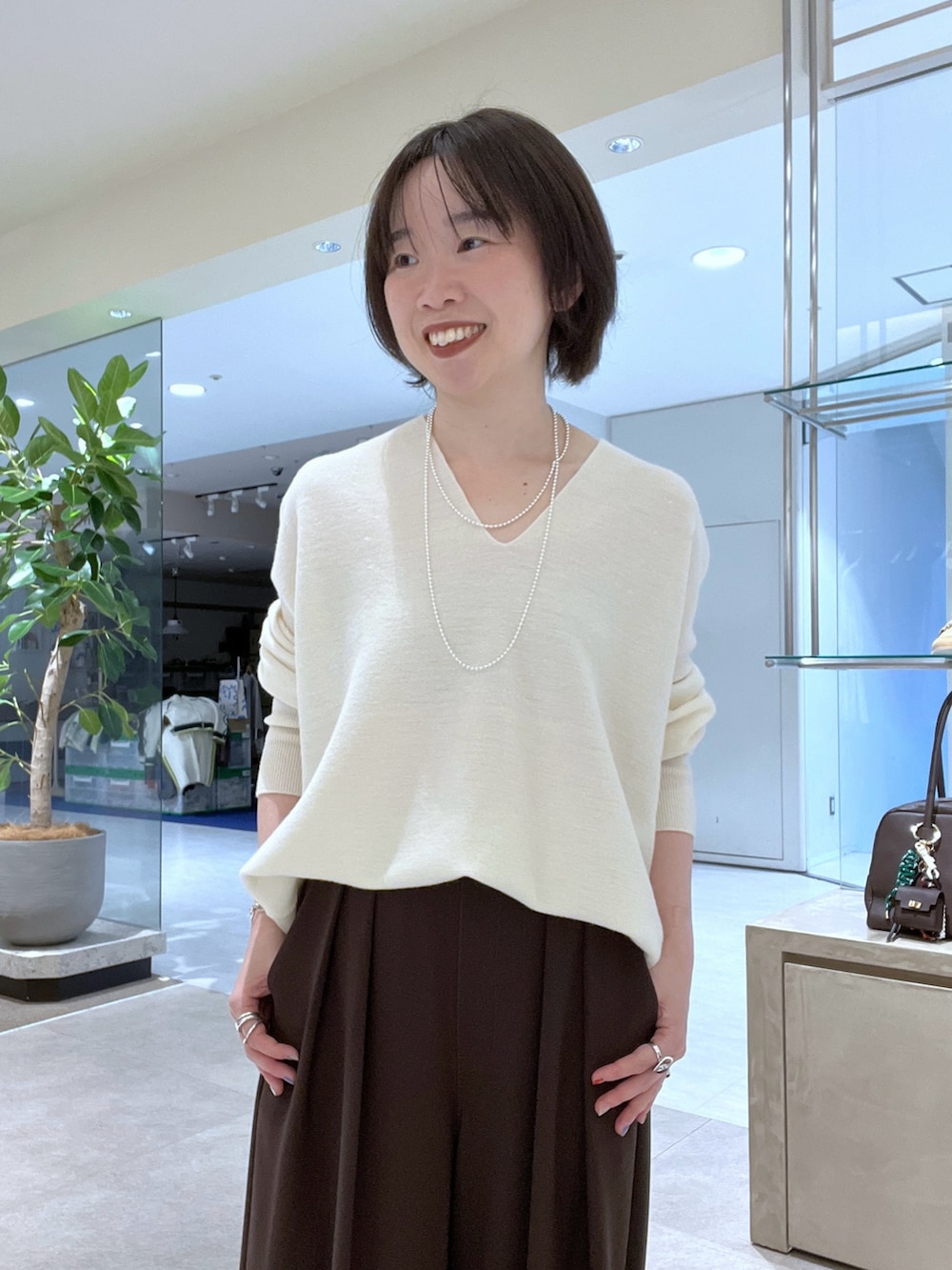 イエロー系のその他アウター、ホワイト系のニット/セーター、ブラウン系のスラックスを着用したレディースの秋コーディネートの8枚目の写真