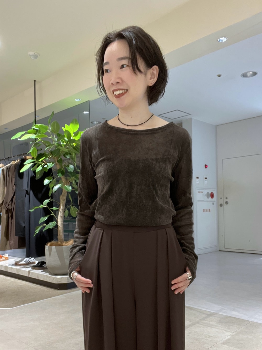 ブラウン系のスラックス、ブラック系のパンプス、ブラウン系のTシャツ/カットソーを着用したレディースの秋コーディネートの8枚目の写真