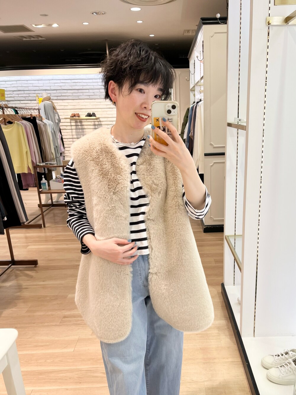 ブラック系のブーツ、ホワイト系のベスト、ブラック系のTシャツ/カットソーを着用したレディースの冬コーディネートの2枚目の写真