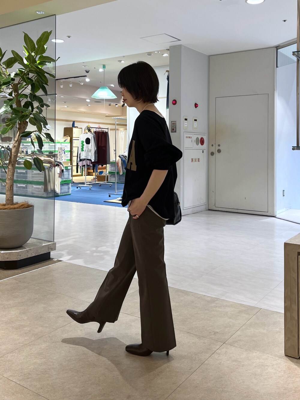 ブラウン系のその他パンツ、ブラウン系のボストンバッグ、ブラウン系のブーツを着用したレディースの秋コーディネートの7枚目の写真