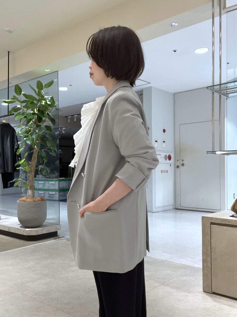 グレー系のテーラードジャケット、ホワイト系のシャツ/ブラウス、ブルー系のスラックスを着用したレディースの冬コーディネートの4枚目の写真