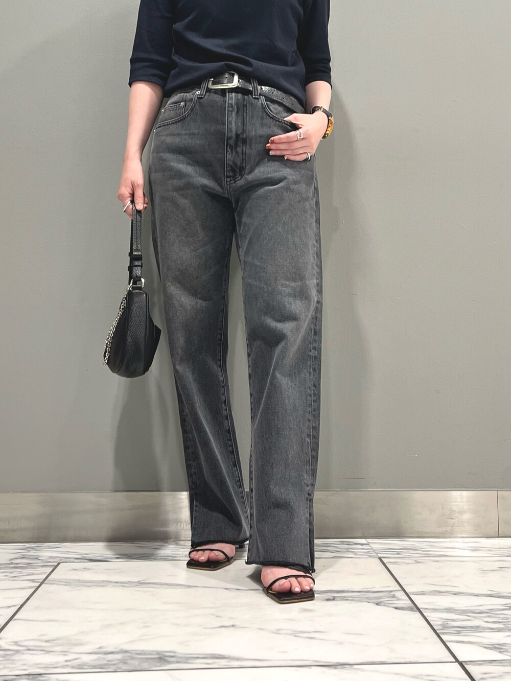 グレー系のデニムパンツ、ブルー系のTシャツ/カットソー、ブラック系のハンドバッグを着用したレディースの夏コーディネートの3枚目の写真