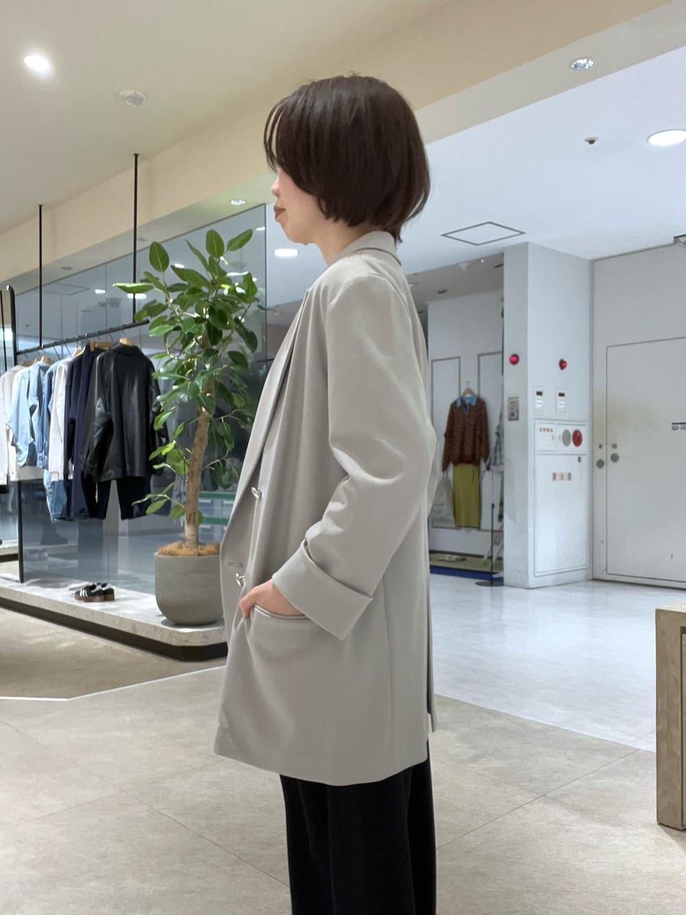 グレー系のテーラードジャケット、ブルー系のスラックス、ブラック系のボストンバッグを着用したレディースの冬コーディネートの5枚目の写真