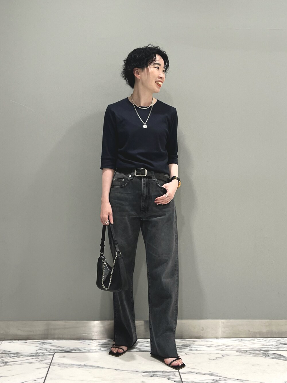 グレー系のデニムパンツ、ブルー系のTシャツ/カットソー、ブラック系のハンドバッグを着用したレディースの夏コーディネートの2枚目の写真