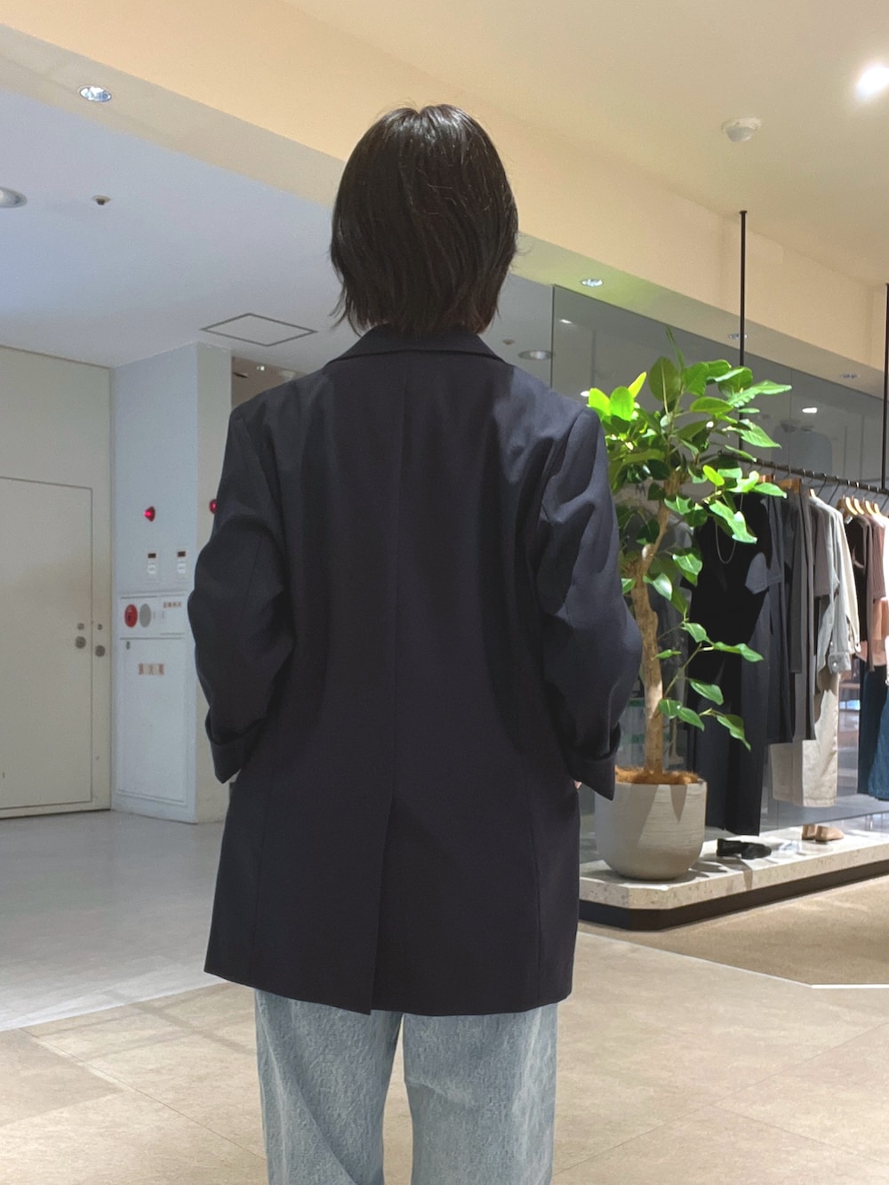 ブルー系のデニムパンツ、ブラック系のパンプス、ブラック系のボストンバッグを着用したレディースの夏コーディネートの6枚目の写真