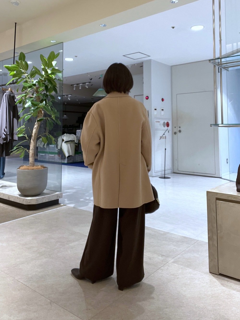 イエロー系のその他アウター、ホワイト系のニット/セーター、ブラウン系のスラックスを着用したレディースの秋コーディネートの3枚目の写真