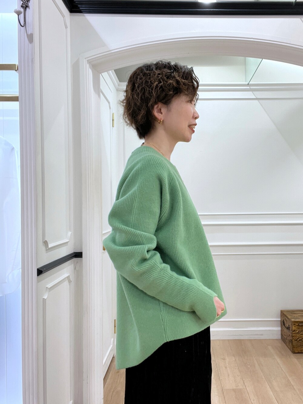 ブラック系のスカート、グリーン系のニット/セーター、ブラック系のショルダーバッグを着用したレディースの冬コーディネートの4枚目の写真