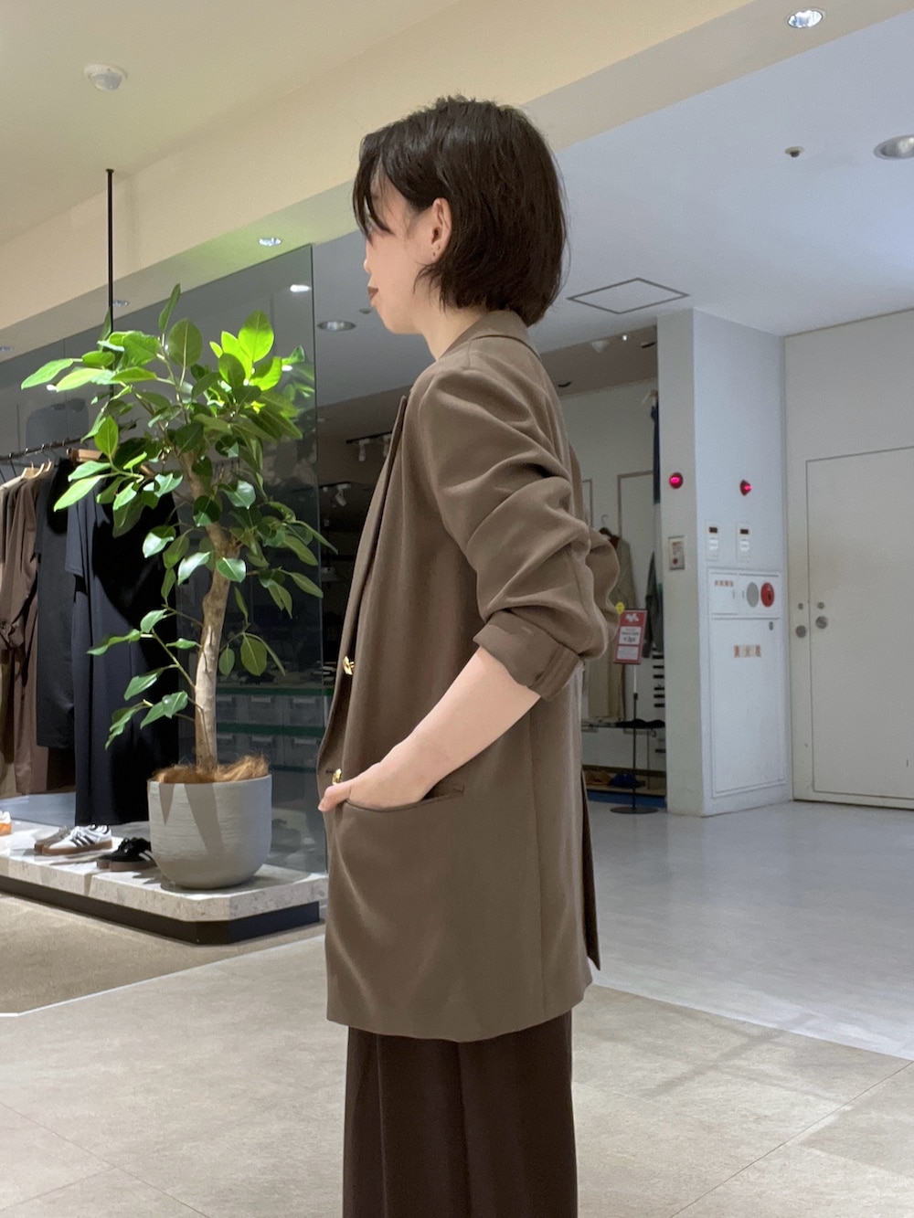 ブラウン系のスラックス、ブラック系のパンプス、ブラウン系のTシャツ/カットソーを着用したレディースの秋コーディネートの6枚目の写真