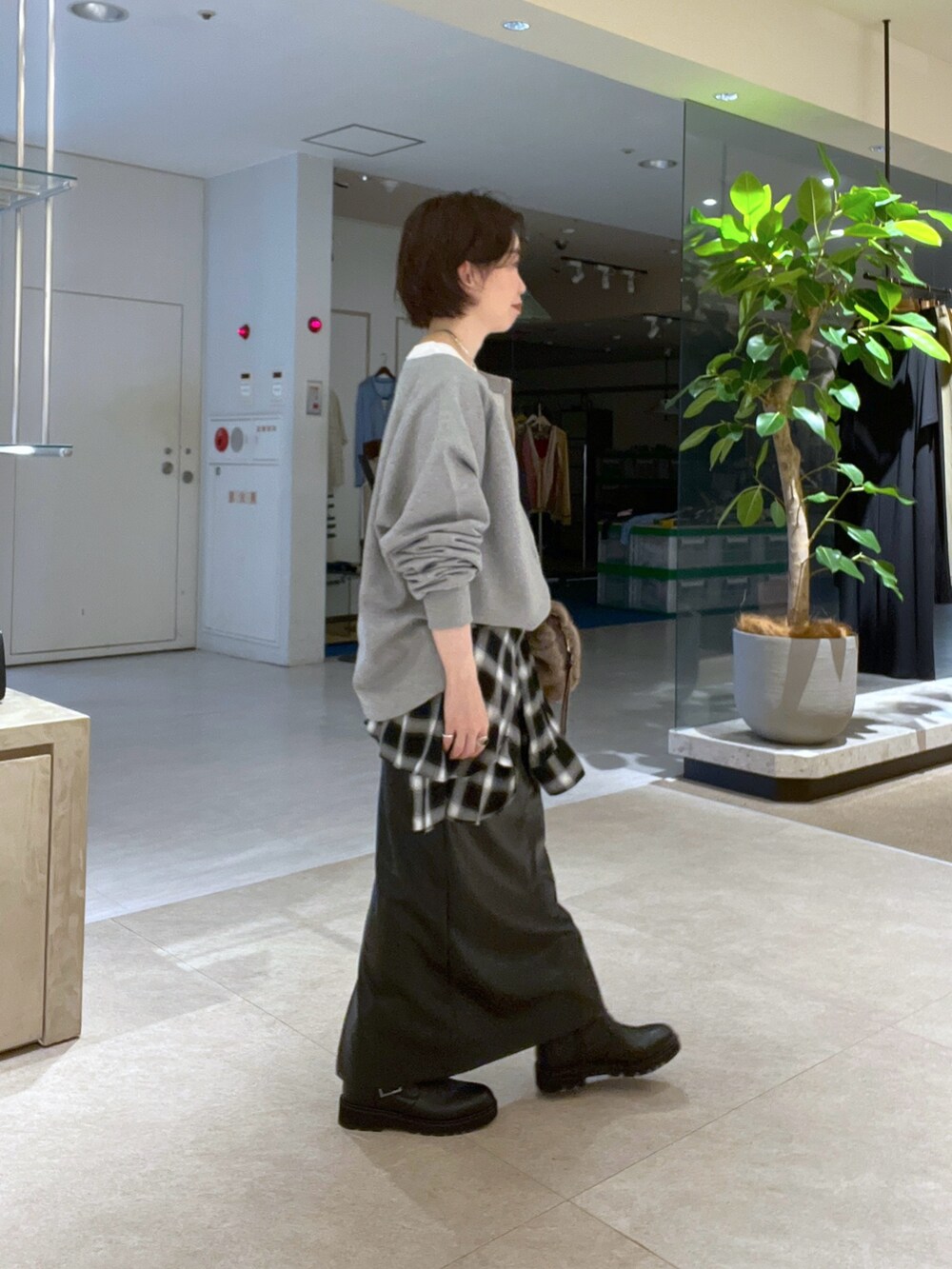 グレー系のスウェット、ブラウン系のハンドバッグ、ブラック系のシャツ/ブラウスを着用したレディースの秋コーディネートの2枚目の写真