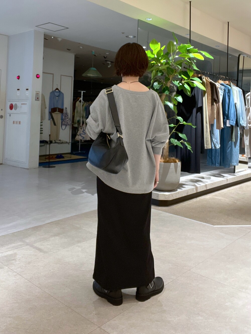 ブラック系のワンピース、グレー系のスウェット、ブラック系のショルダーバッグを着用したレディースの秋コーディネートの3枚目の写真