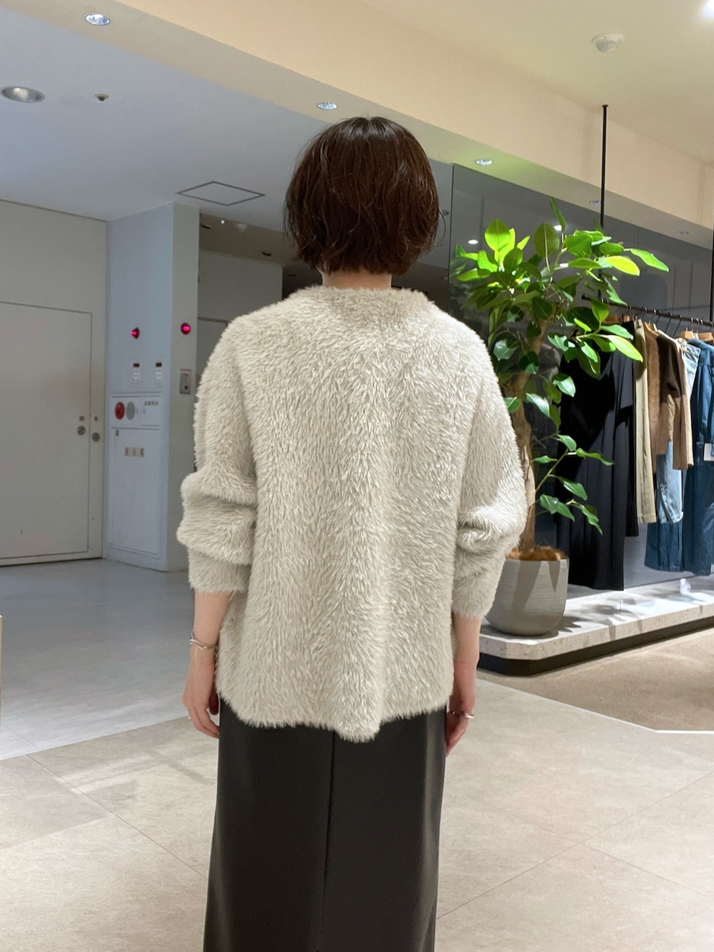 ベージュ系のカーディガン/ボレロ、ブラック系のスカート、ホワイト系のTシャツ/カットソーを着用したレディースの秋コーディネートの6枚目の写真