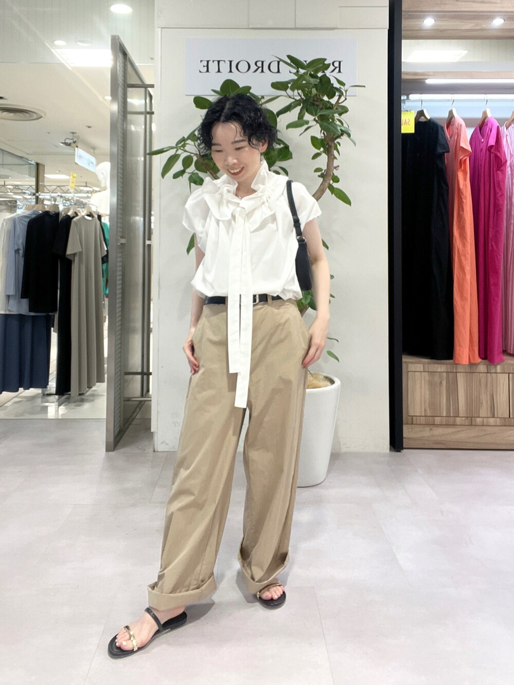 ベージュ系のその他パンツ、ホワイト系のシャツ/ブラウス、ブラック系のサンダルを着用したレディースの夏コーディネートの2枚目の写真