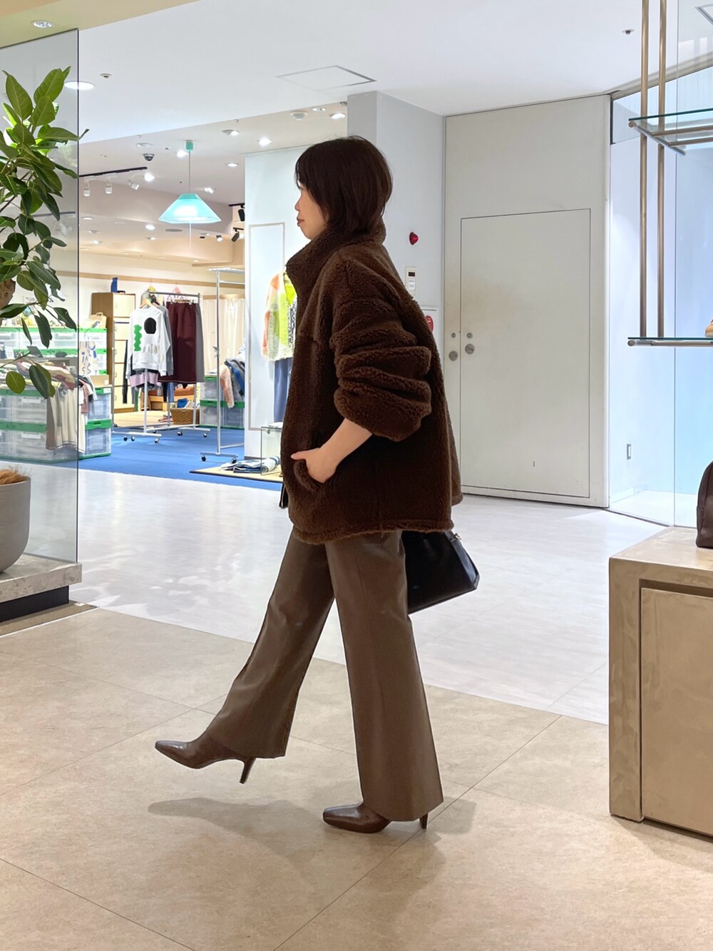 ブラウン系のその他パンツ、ブラウン系のボストンバッグ、ブラウン系のブーツを着用したレディースの秋コーディネートの2枚目の写真