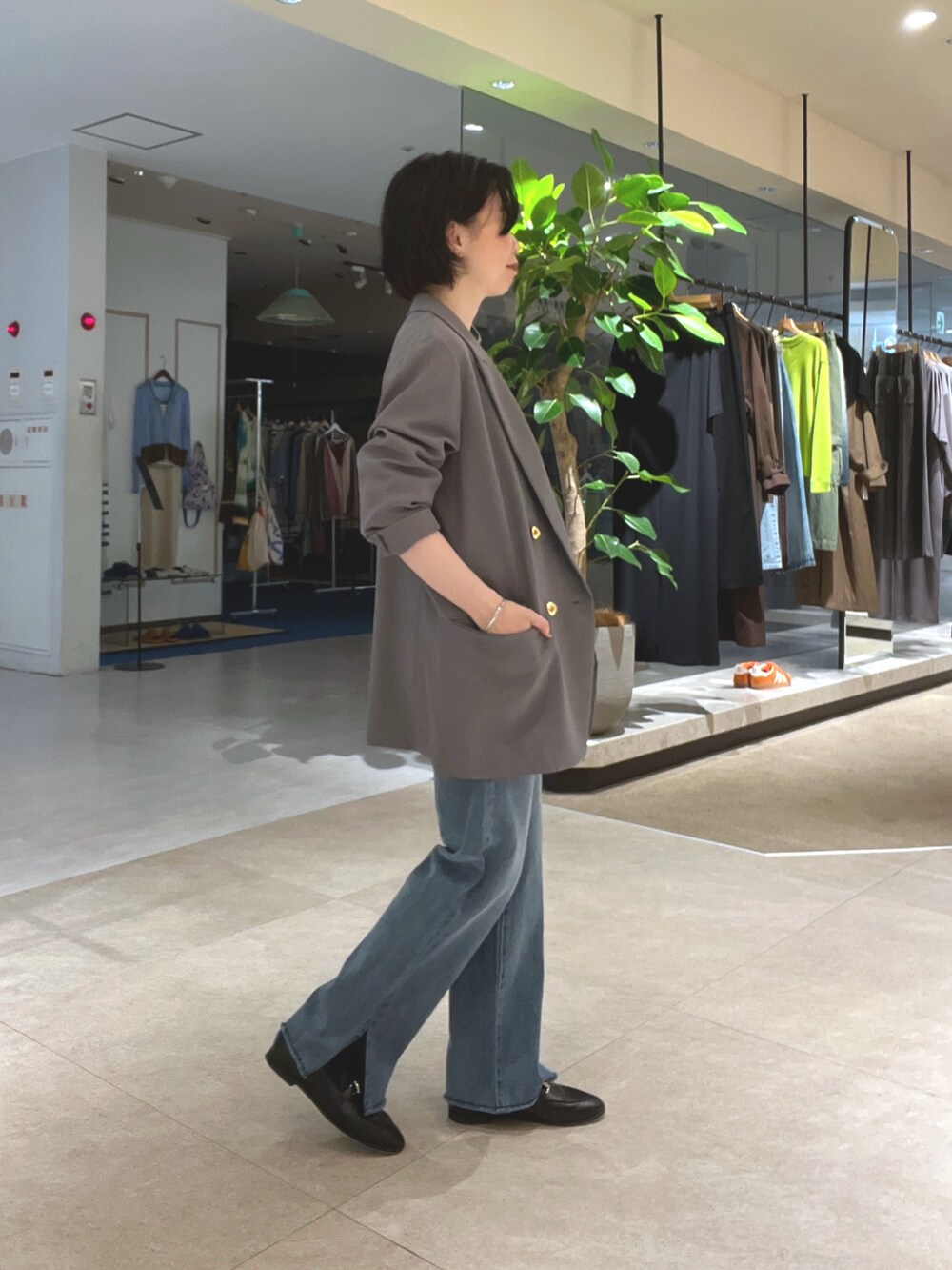 ホワイト系のTシャツ/カットソー、ブルー系のデニムパンツ、ブラック系のローファーを着用したレディースの秋コーディネートの2枚目の写真