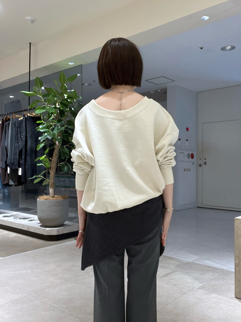 ホワイト系のTシャツ/カットソー、グレー系のその他パンツ、ブラック系のブーツを着用したレディースの冬コーディネートの6枚目の写真