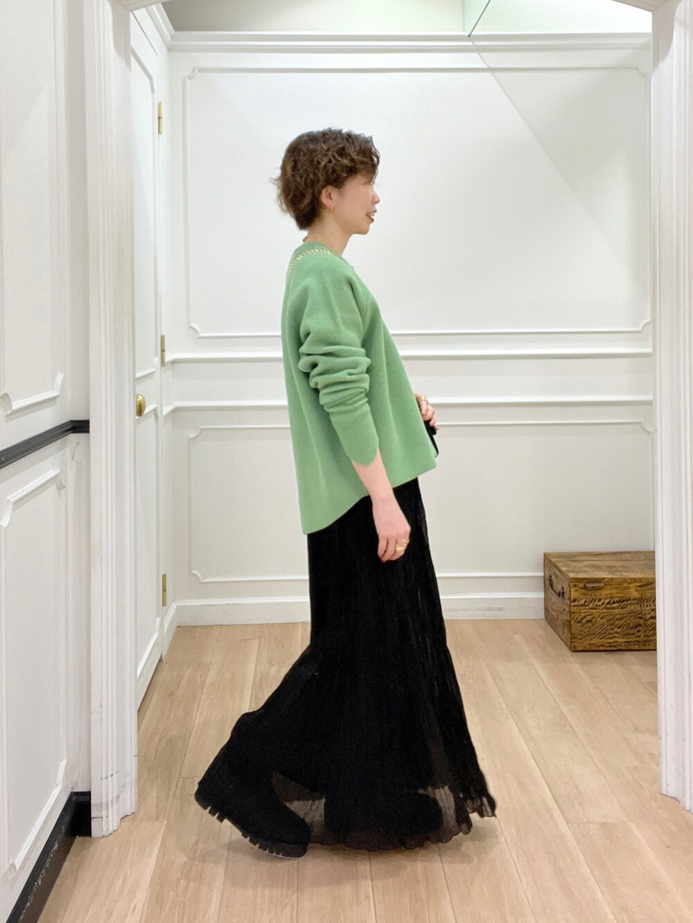 ブラック系のスカート、グリーン系のニット/セーター、ブラック系のショルダーバッグを着用したレディースの冬コーディネートの2枚目の写真