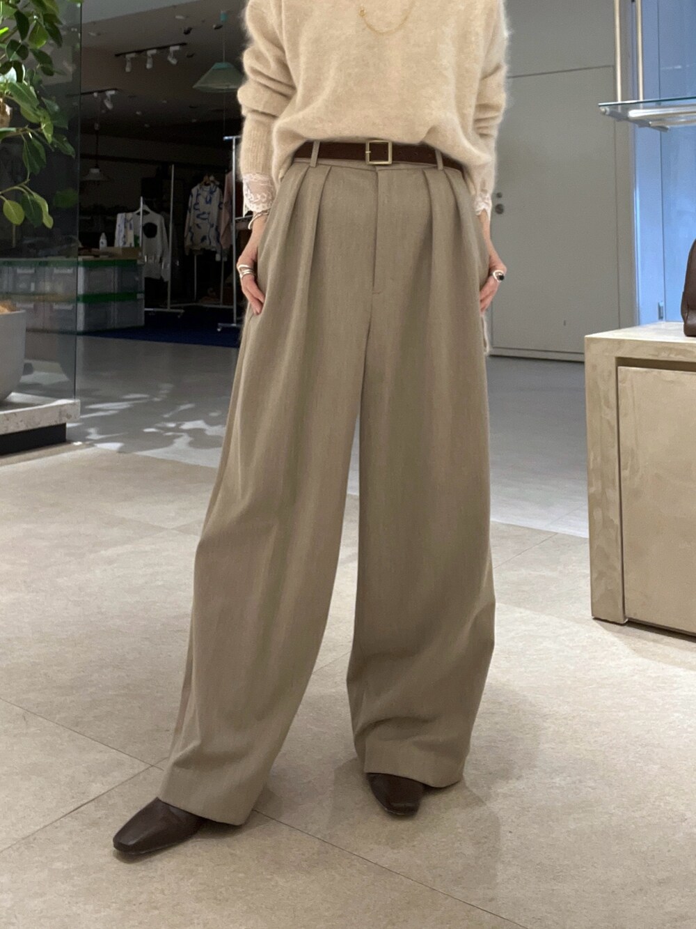 ブラウン系のトートバッグ、ベージュ系のスラックス、ブラウン系のブーツを着用したレディースの秋コーディネートの10枚目の写真