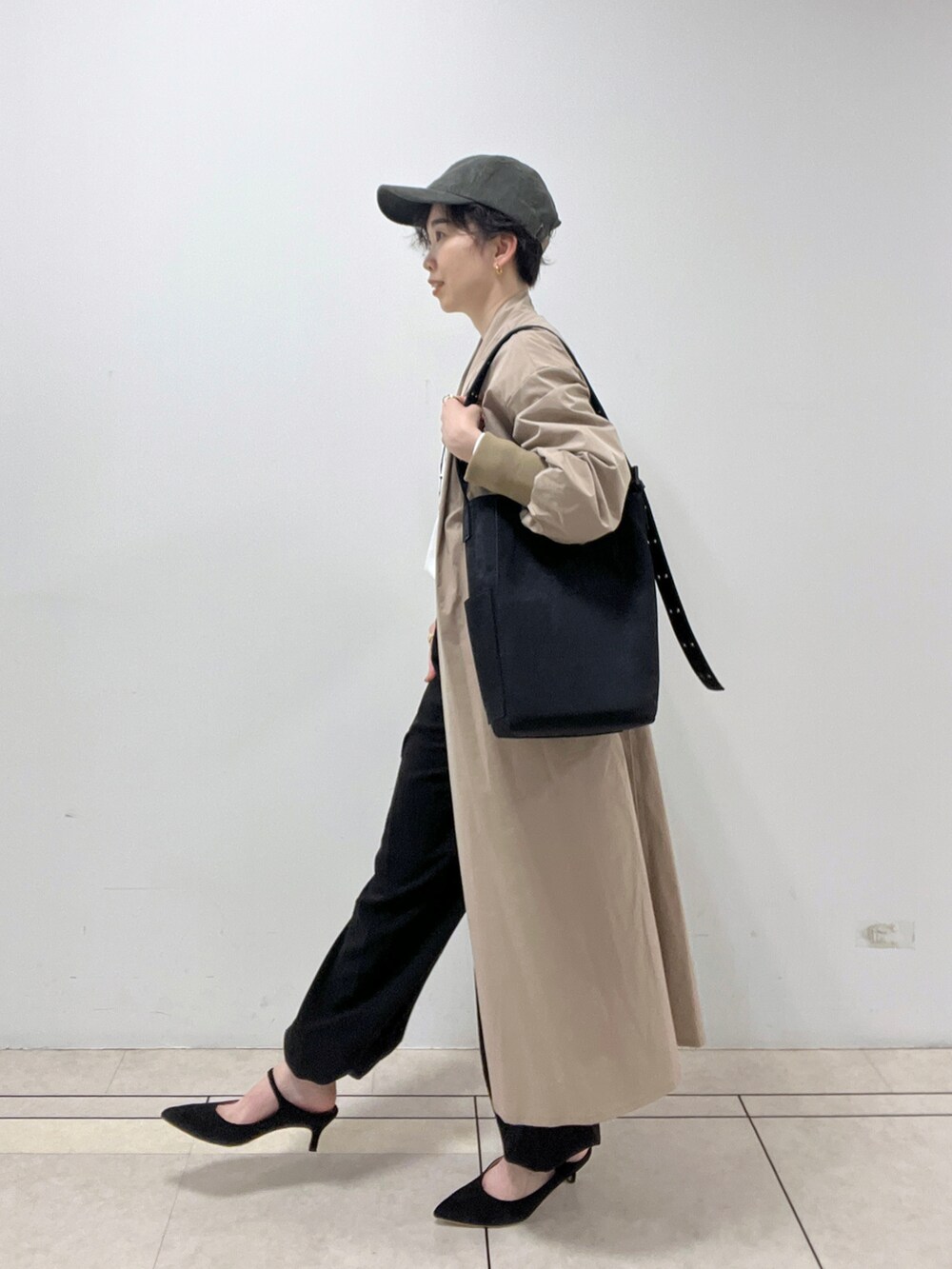 ブラック系のカーゴパンツ、ベージュ系のノーカラーコート、ホワイト系のTシャツ/カットソーを着用したレディースの秋コーディネートの2枚目の写真