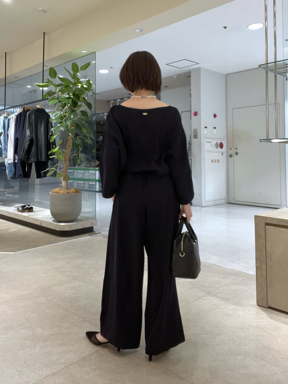 グレー系のテーラードジャケット、ブルー系のスラックス、ブラック系のボストンバッグを着用したレディースの冬コーディネートの9枚目の写真