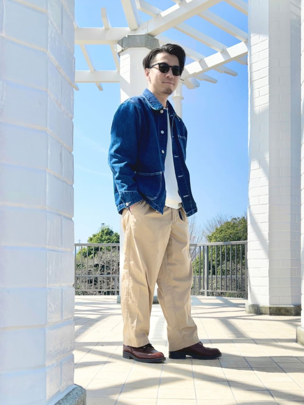 ホワイト系のTシャツ/カットソー、ブルー系のカバーオール、ベージュ系のチノパンツを着用したメンズの春コーディネートの2枚目の写真