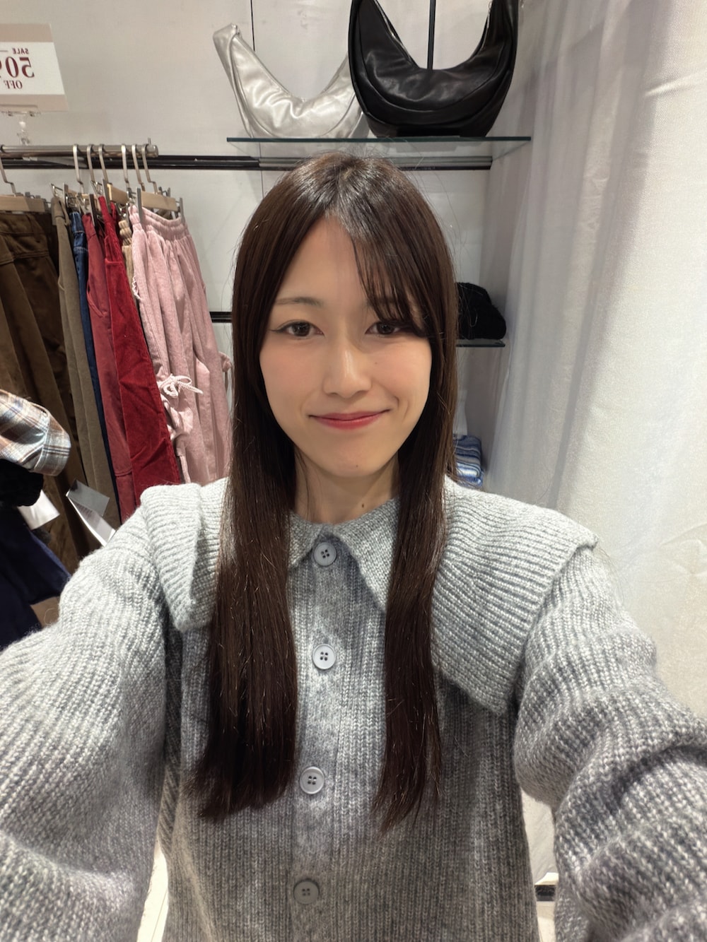 グレー系のトップス、ブラック系のパンツを着用したレディースの冬コーディネートの3枚目の写真