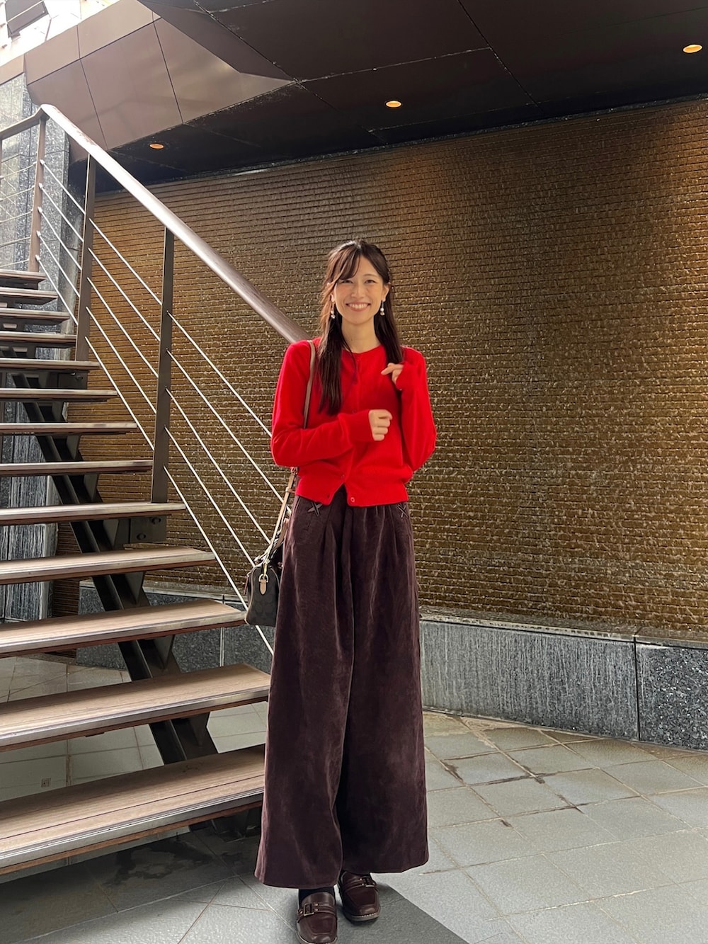 レッド系のジャケット/アウター、ブラウン系のシューズを着用したレディースの冬コーディネートの2枚目の写真